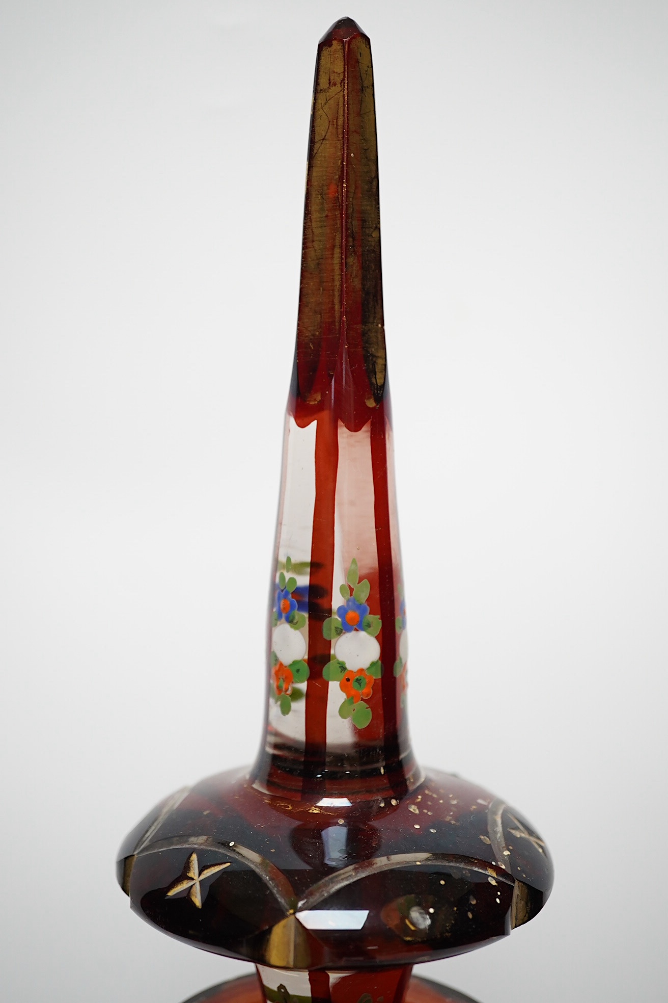 An early 20th century Bohemian overlaid and painted ruby glass decanter, 51cm. Condition - fair